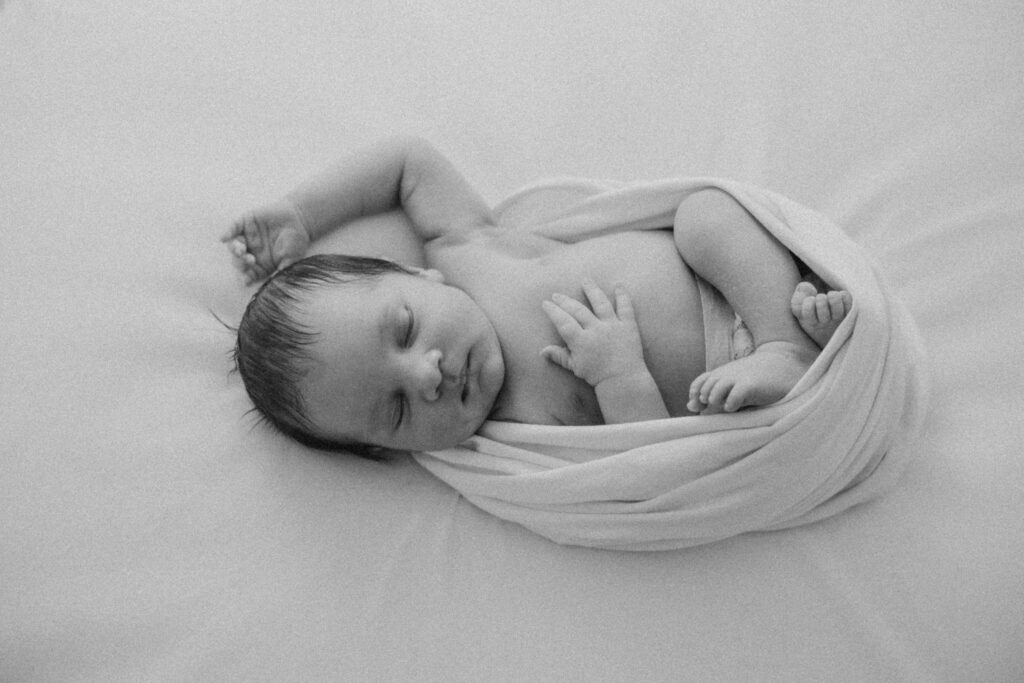 vauvakuva jossa vauva yksin luonnonvalkoisessa kapalossa