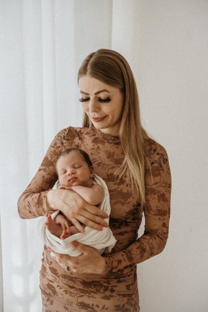 Newborn studiokuvaus Helsingissä – vauva ja vanhempi lähekkäin