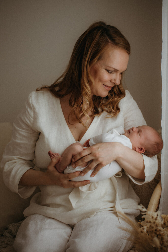 Vauvakuvaus studilla missä äiti katsoo vasta syntynyttä lastaan