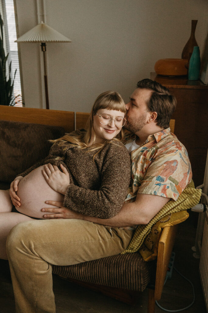 lifestyle-odotuskuvaus jossa puoliso pussaa kumppaniaan valokuvassa