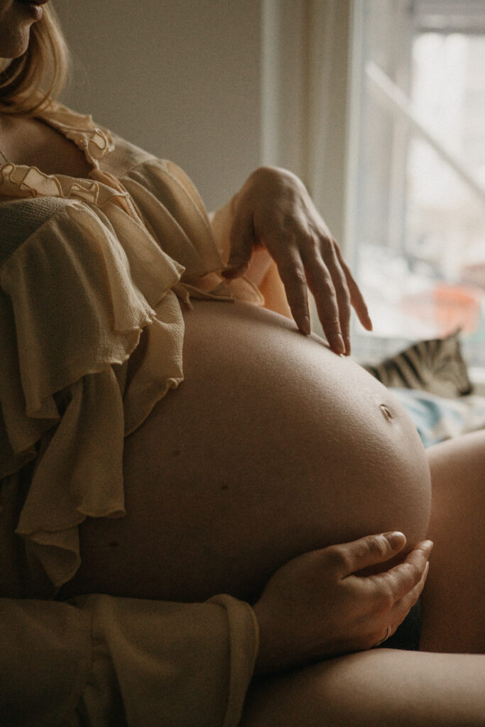 lifestyle-odotuskuvaus sängyllä lähikuva mahasta