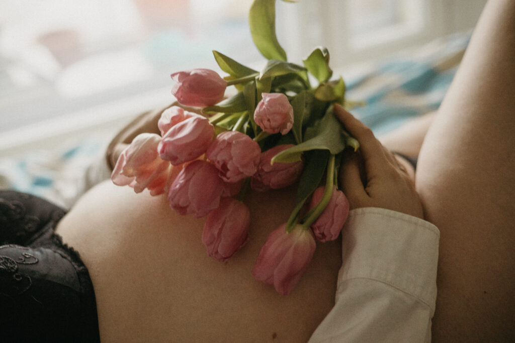 raskausvatsa luonnonvalossa kotona tulppanien kanssa