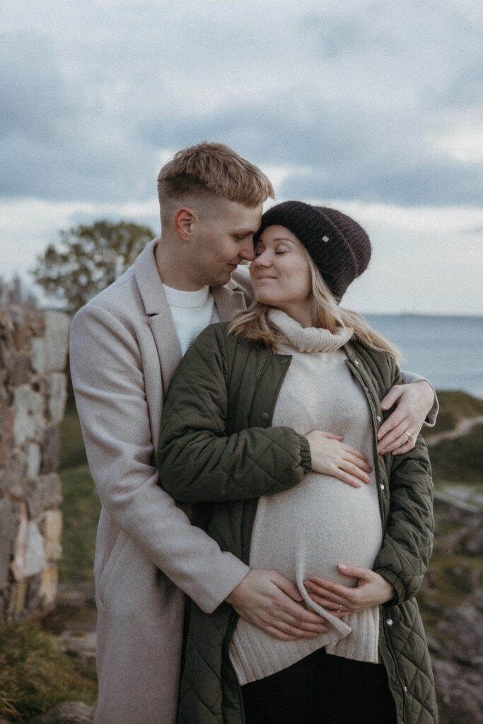 pariskunta suomenlinnassa ja katsoo toisiaan herkästi, molempien kädet tulevan äidin mahalla