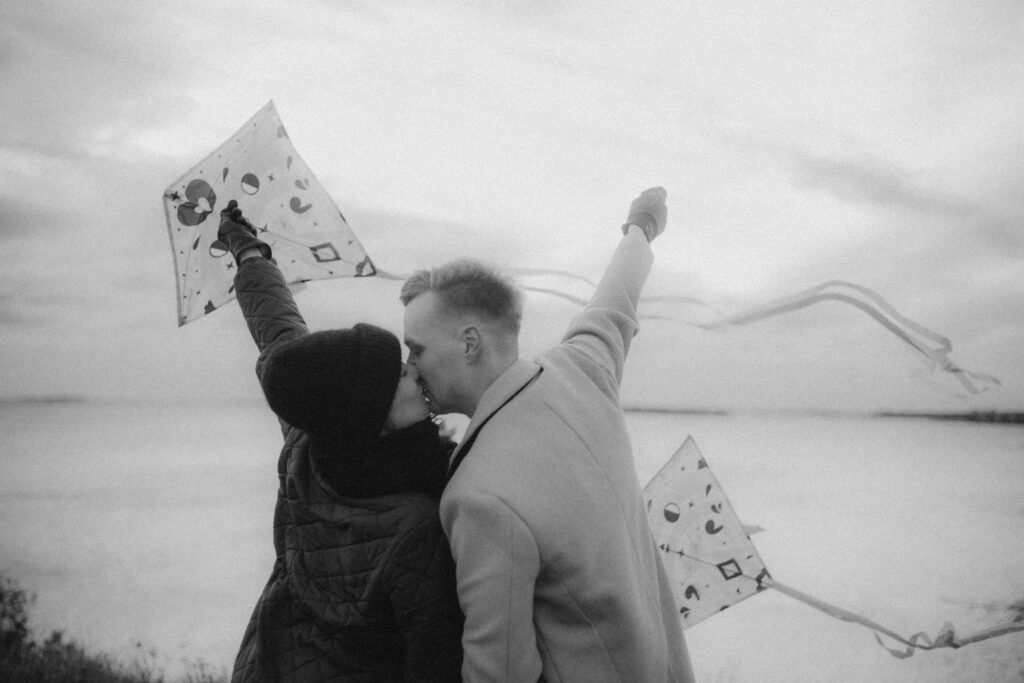 Odotuskuvat merimaisemassa Helsingissä – raskauskuvaus jossa pariskunta lennättää leijaa