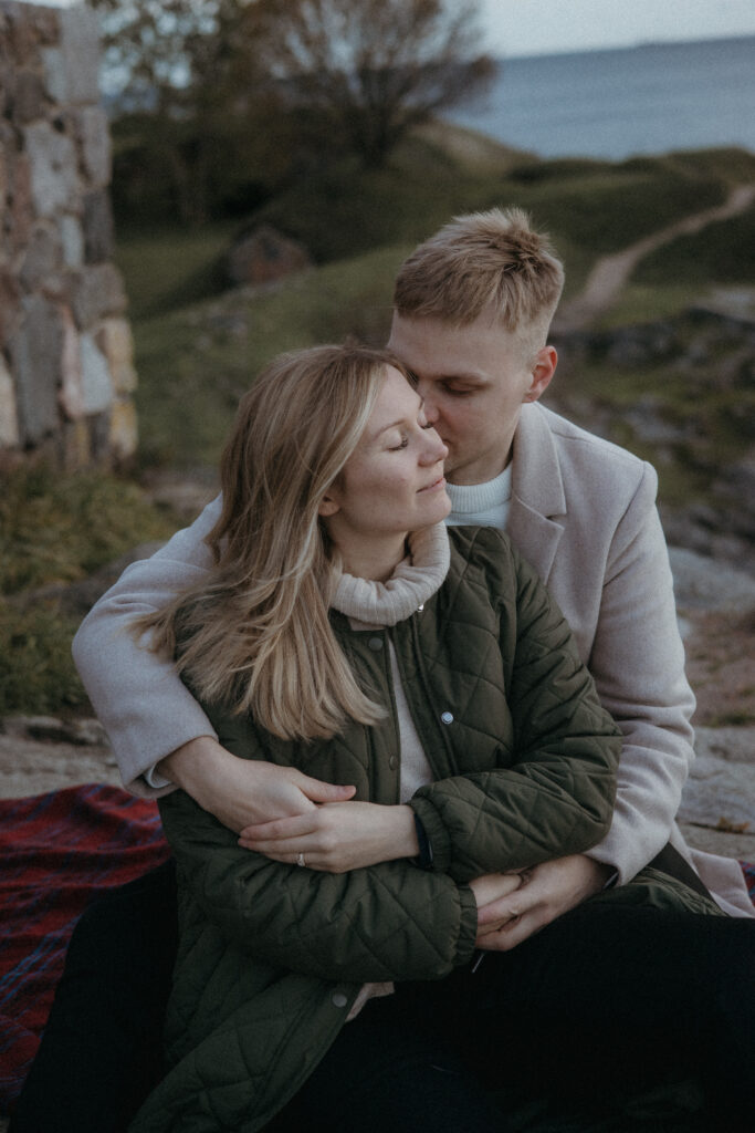 lähikuva pariskunnasta jotka istuvat lähekkäin Suomenlinnassa