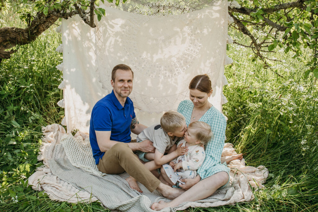 perhekuvassa poika pussaa siskoaan