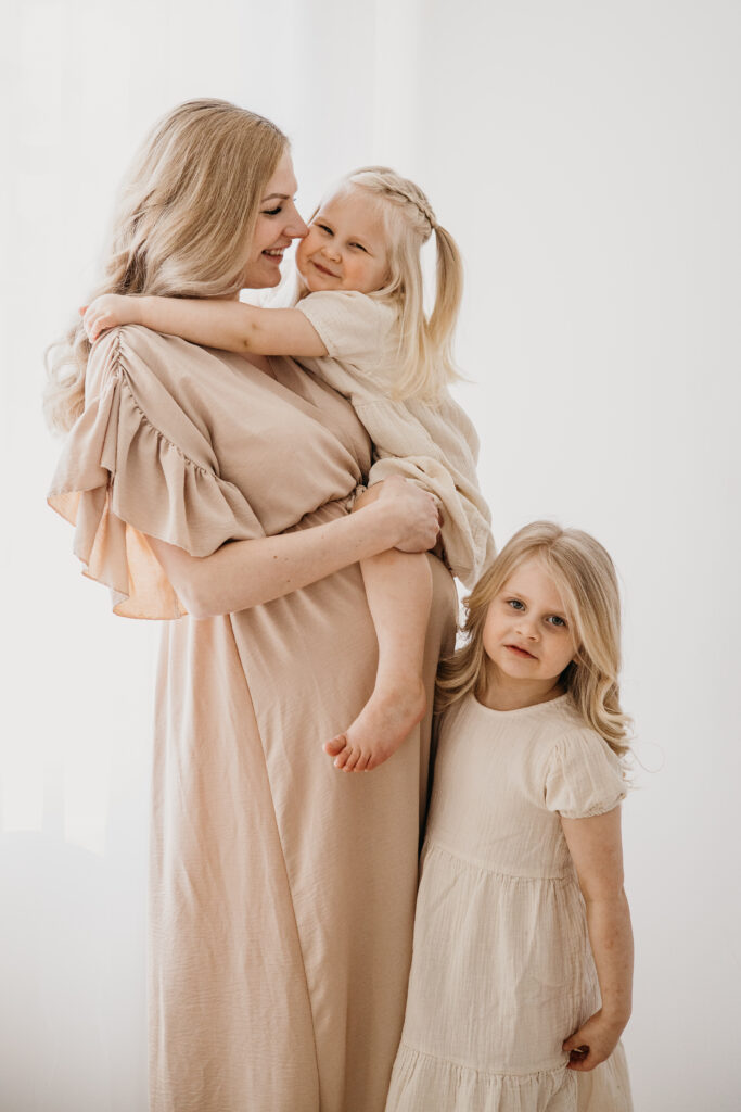 äiti ja kaksi tytärtä perhekuvauksessa