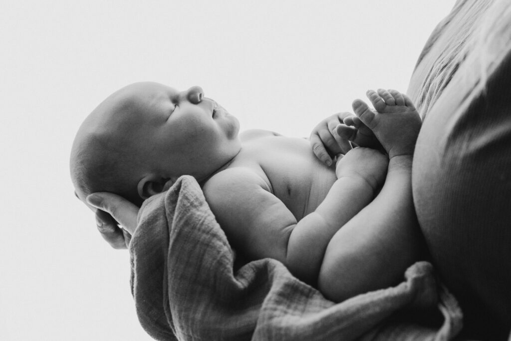mustavalkoinenkuva jossa vauva on vanhempien sylissä