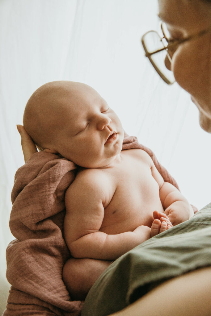 ihana vastasyntynyt tyttövauva kuvattuna vanhemman sylissä