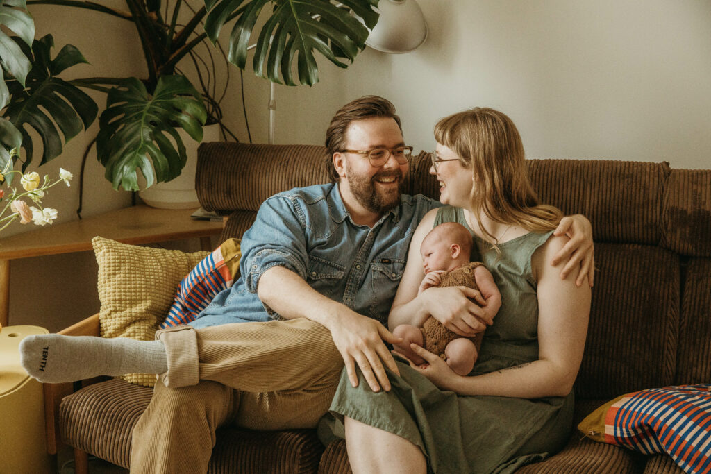 äiti ja isä pitävät vastasyntynyttä vauvaa sylissä